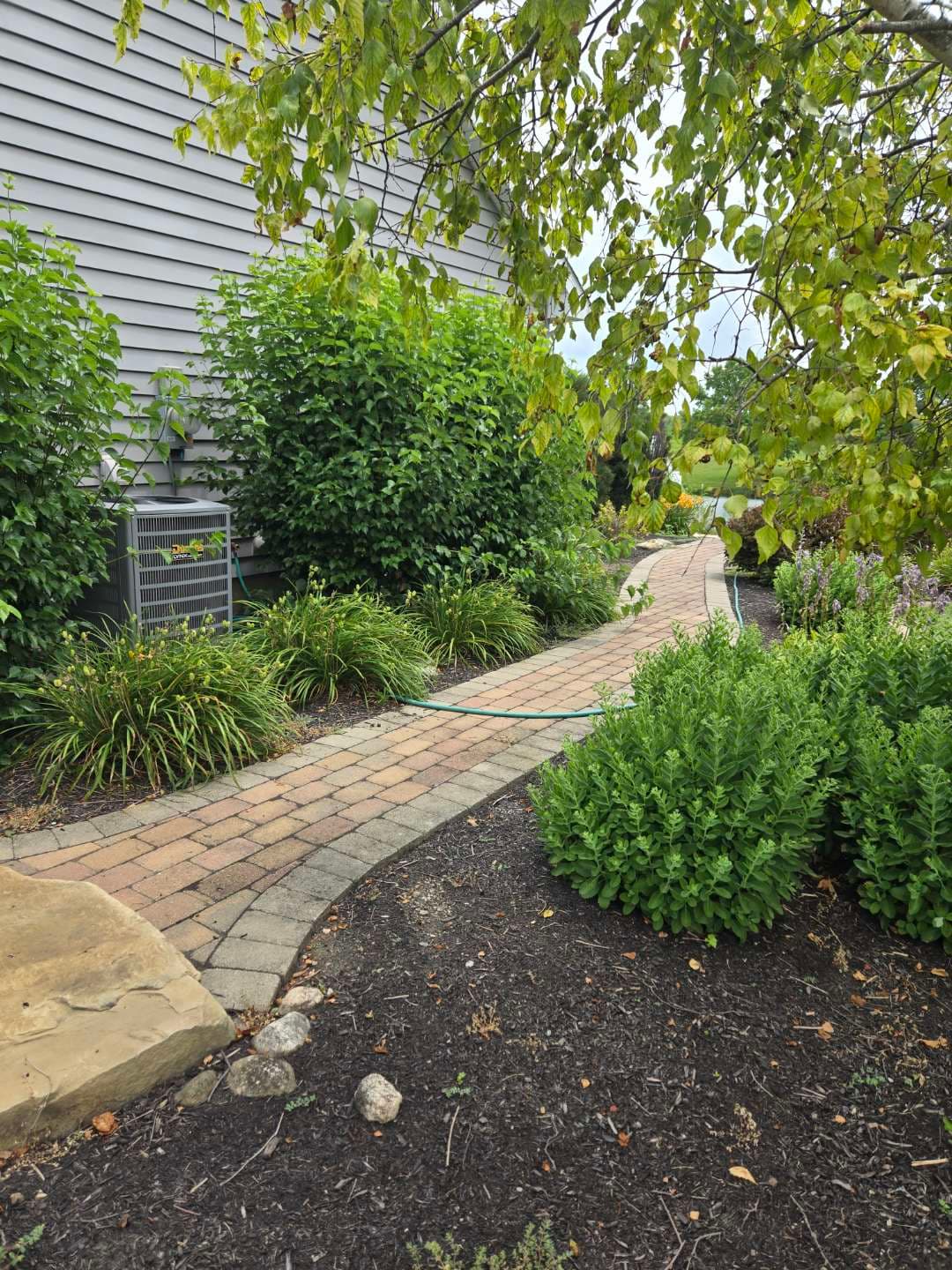 Brick paver pathway with garden beds and fresh mulch — Jarjus Lawn Care